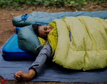 Sleepy backpacker wrapped in quilt